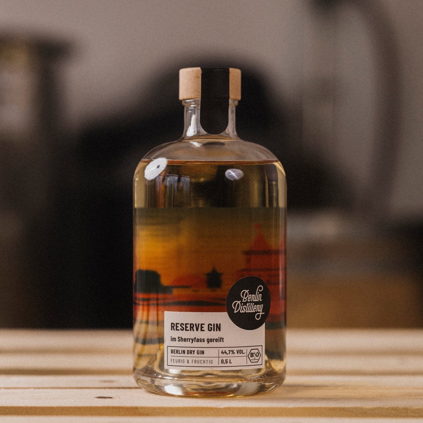 Eine Flasche Berlin Distillery Reserve gin steht auf einer Holzpalette vor dem Hintergrund der Produktionseinrichtung.