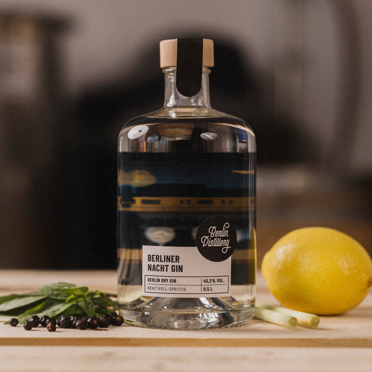 Eine Flasche BERLINER NACHT GIN der Berlin Distillery mit frischer Zitrone, Wacholderbeeren und Zitronengras.