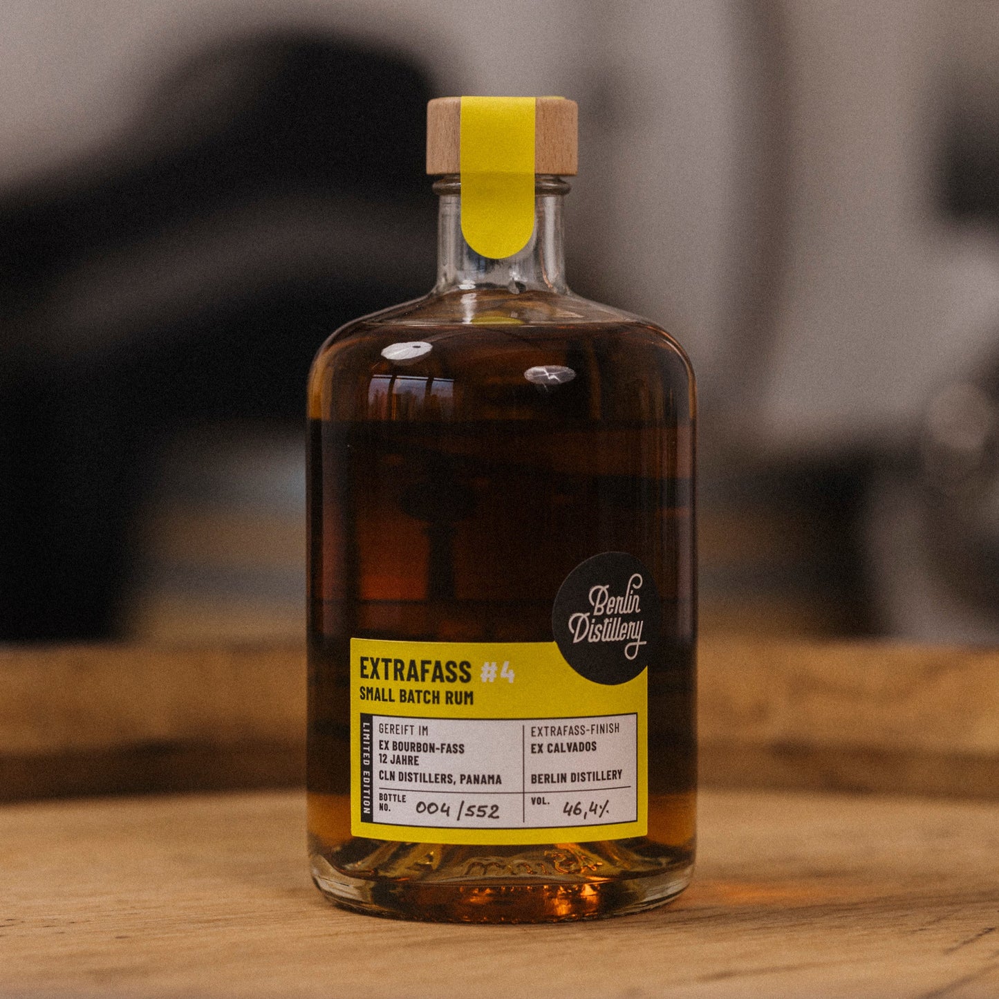 Eine Flasche EXTRAFASS #4 Small Batch Rum der Berlin Distillery steht auf einem Holzfass.