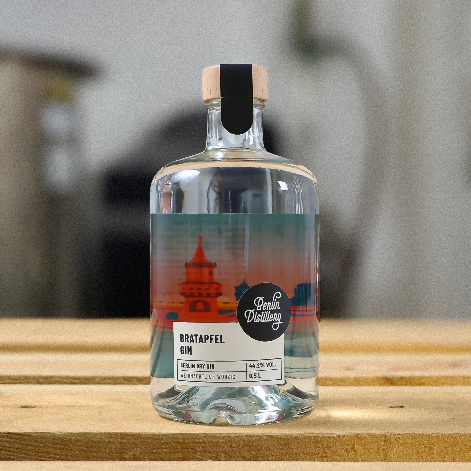 Eine Flasche Berlin Distillery Bratapfel Gin steht auf einer Holzpalette vor der Produktionsanlage.