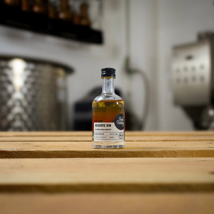 Eine kleine Flasche Berlin Distillery Reserve Gin steht auf einer Holzpalette vor der Produktionsanlage.