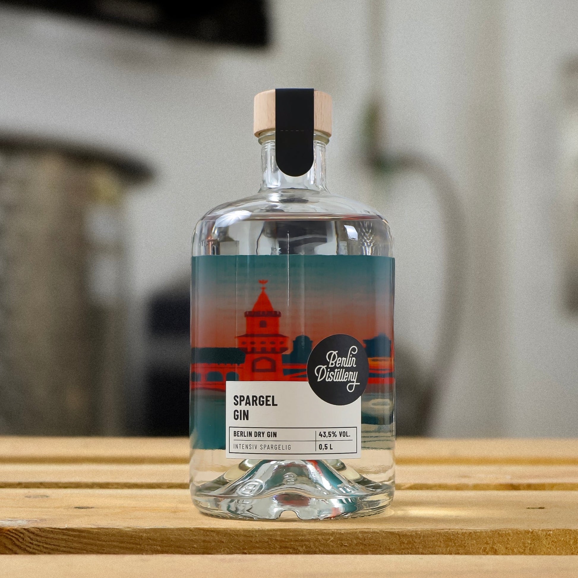 Eine Flasche Berlin Distillery Spargel Gin steht auf einer Holzpalette vor der Produktionsanlage.